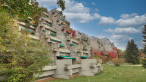 Markante gestufte Betonarchitektur der Terrassenhausanlage mit Bäumen in München-Bogenhausen