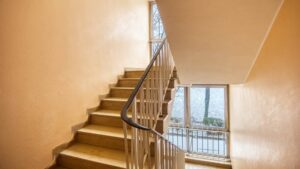 Cast-iron staircase with curved balustrades and large window in a residential building in Munich-Bogenhausen