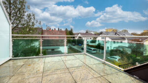 Dachterrasse mit Glasgeländer und Blick über Reihenhäuser in einer Wohnung in München-Forstenried