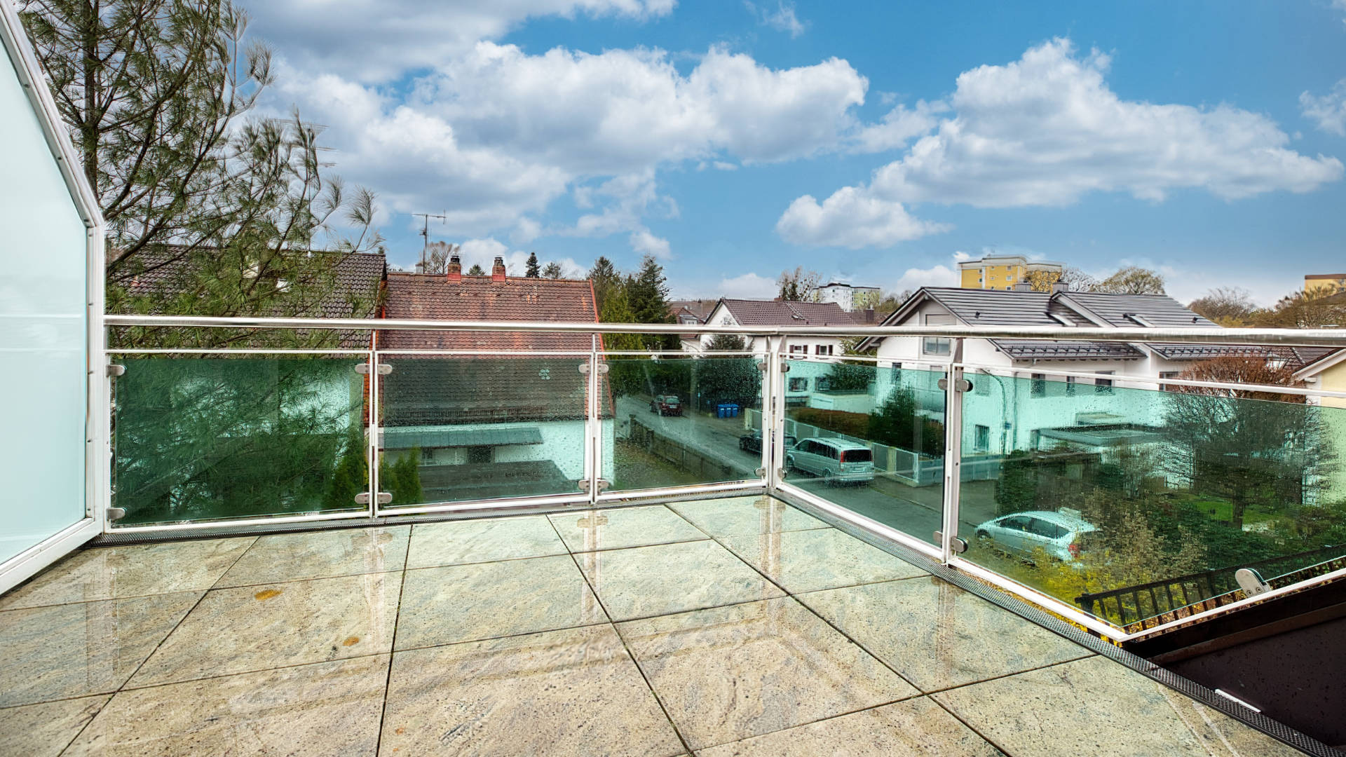 Dachterrasse mit Glasgeländer und Blick über Reihenhäuser in einer Wohnung in München-Forstenried