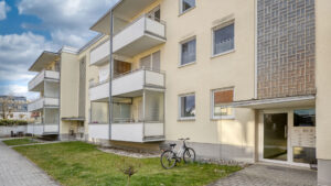 Apartment building with balconies and a lawn in front of the entrance in Germering – Rogers Immobilien