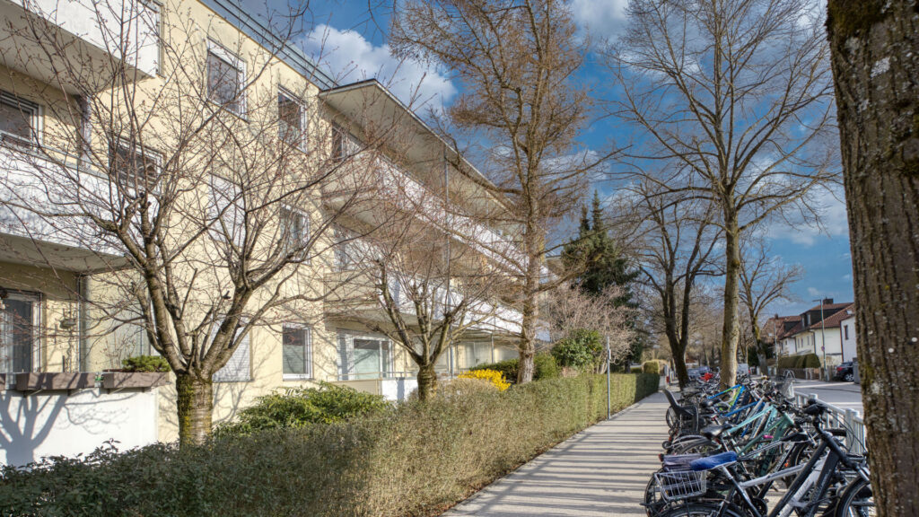 Terraced house row with paved access path and bicycle stands in Germering – Rogers Immobilien