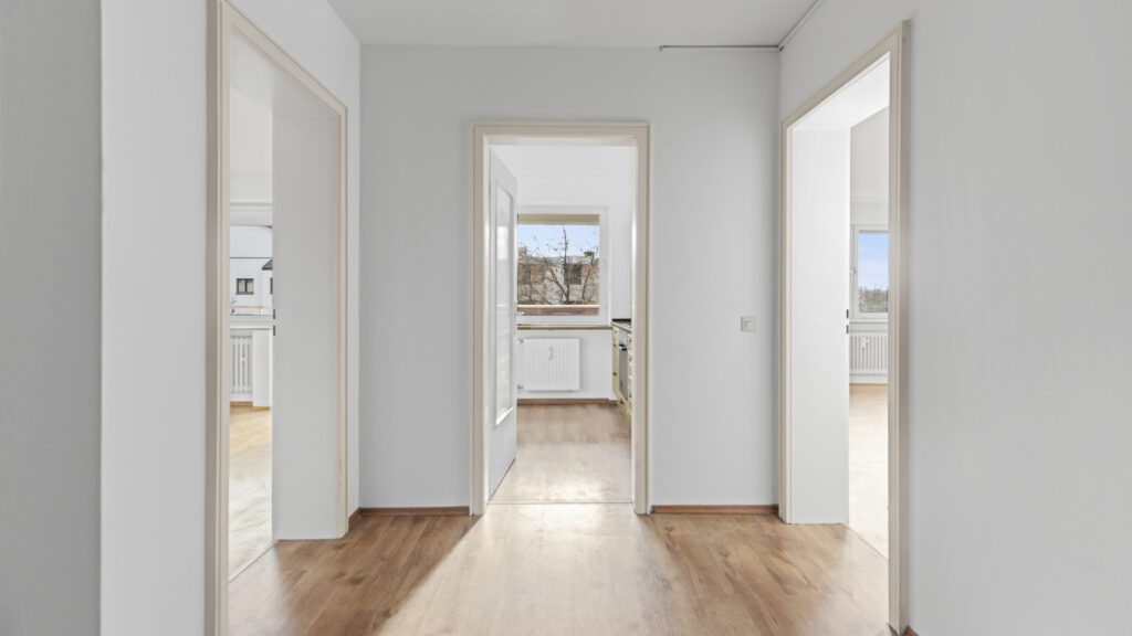 Diele mit hellem Parkettboden und Durchblick zu Küche und Schlafzimmer in einer Wohnung in Germering bei München