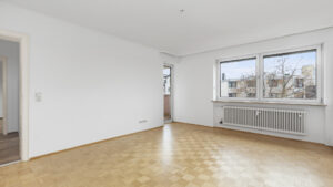 Unmöbliertes Wohnzimmer mit Fischgrätparkett und Fenster in einer Wohnung in Germering bei München