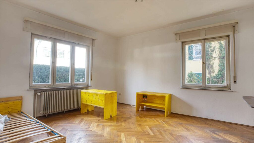 Leeres Zimmer im Erdgeschoss des Einfamilienhauses in München-Großhadern mit Parkettboden