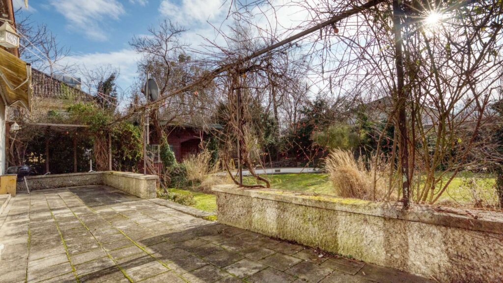 Terrasse mit Pergola des Einfamilienhauses in München-Großhadern und winterlichem Garten