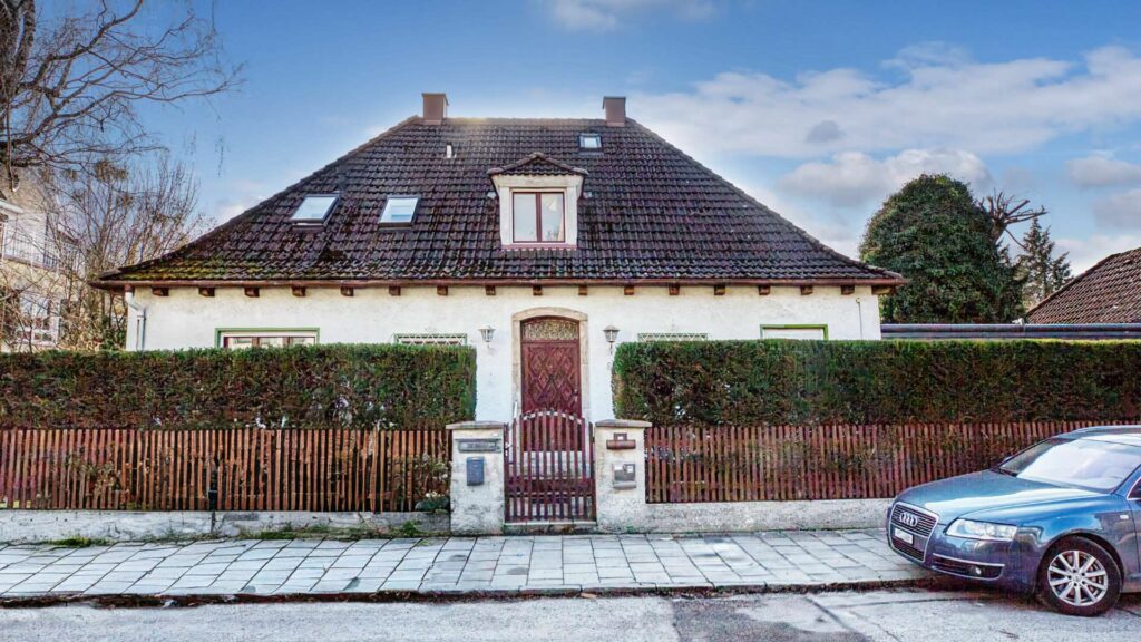 Straßenansicht des Einfamilienhauses in München-Großhadern mit Walmdach und winterlicher Straße