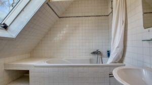 Badezimmer im Obergeschoss des Einfamilienhauses in München-Großhadern mit Badewanne unter der Dachschräge