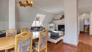 Wohnraum im Dachgeschoss des Einfamilienhauses in München-Großhadern mit Esstisch und Kamin