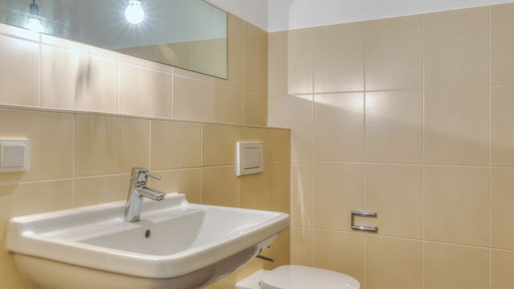 Bathroom in the apartment in Großhadern, Munich, with a sink and beige tiles