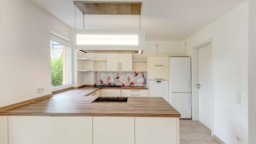 Kitchen in the apartment in Munich-Großhadern with extractor hood and wood worktop