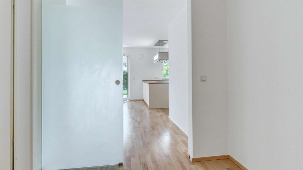 Milk glass sliding door in the apartment in Munich-Großhadern with a view to the kitchen