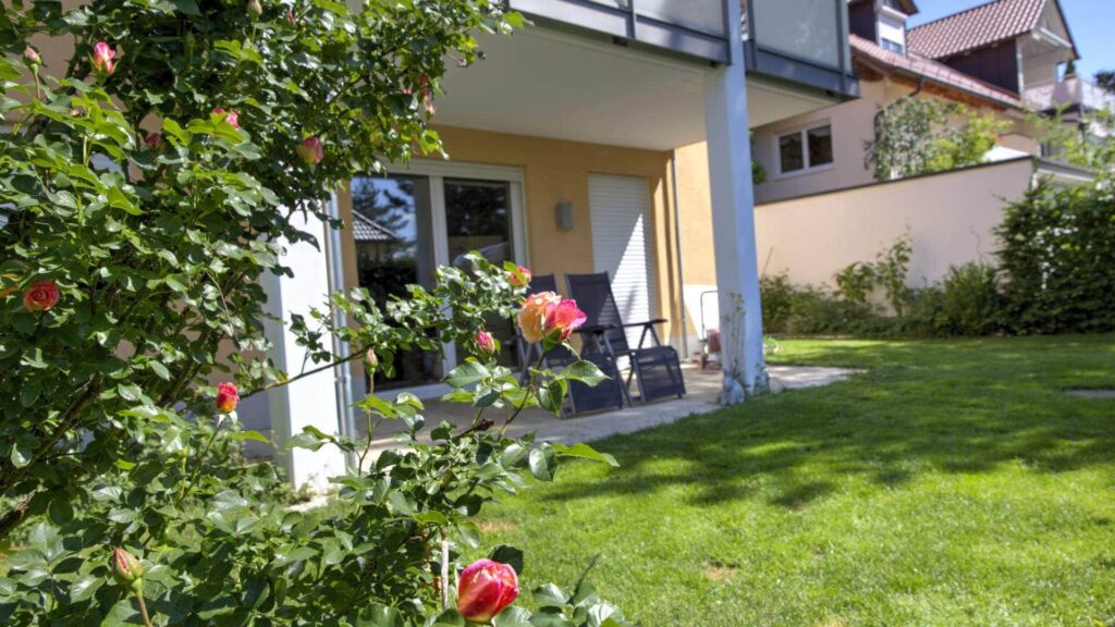Terrace of the apartment in Munich-Großhadern with a flowering rose bush in the foreground