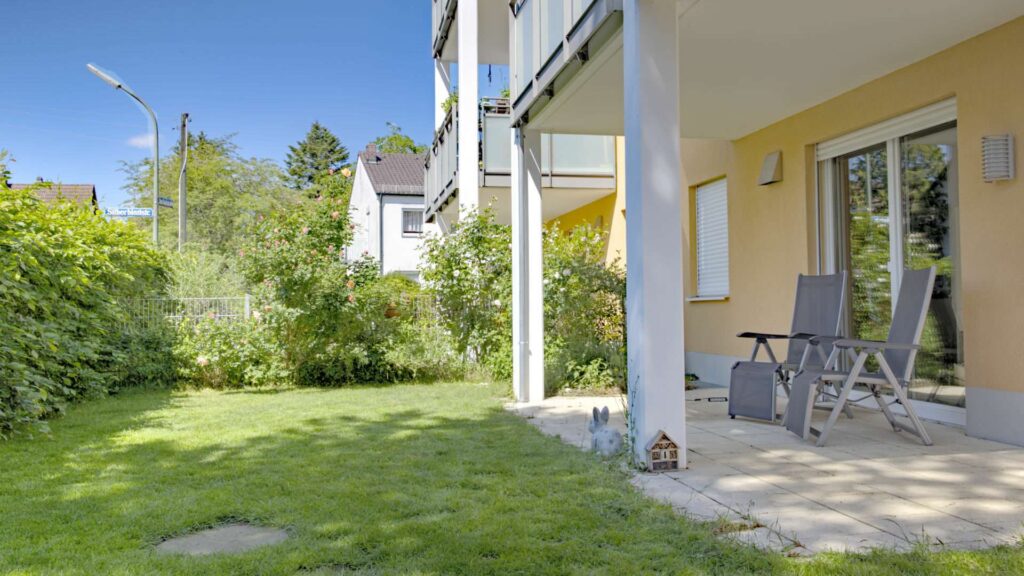 Terrace of the apartment in Munich-Großhadern with seating area and adjacent lawn area