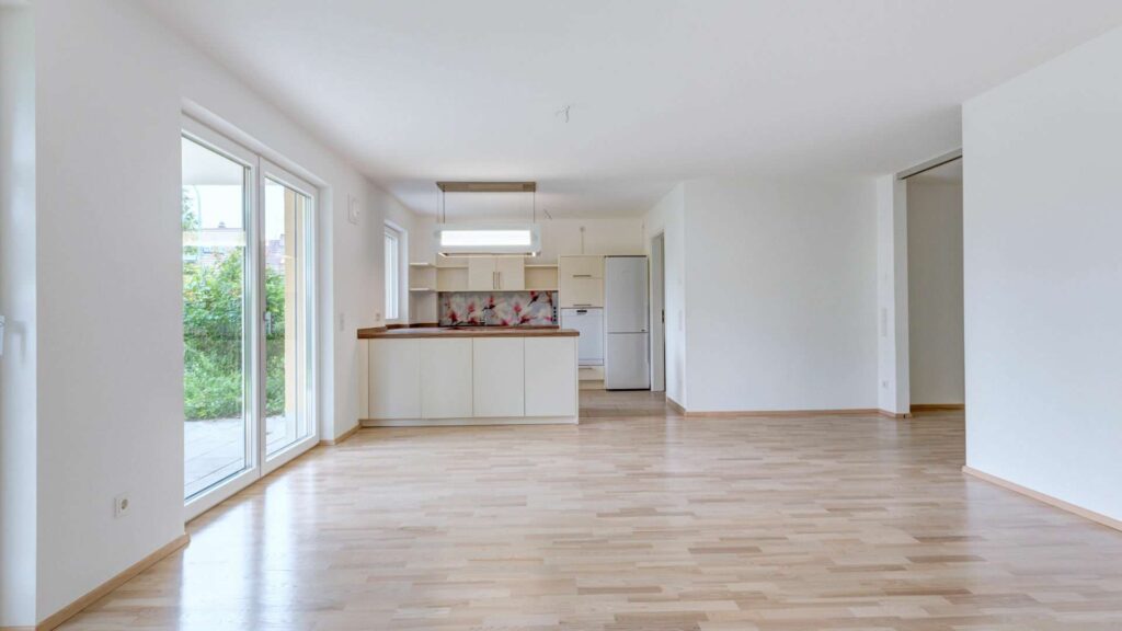 Open kitchen in the apartment in Munich-Großhadern with light parquet and access to the garden