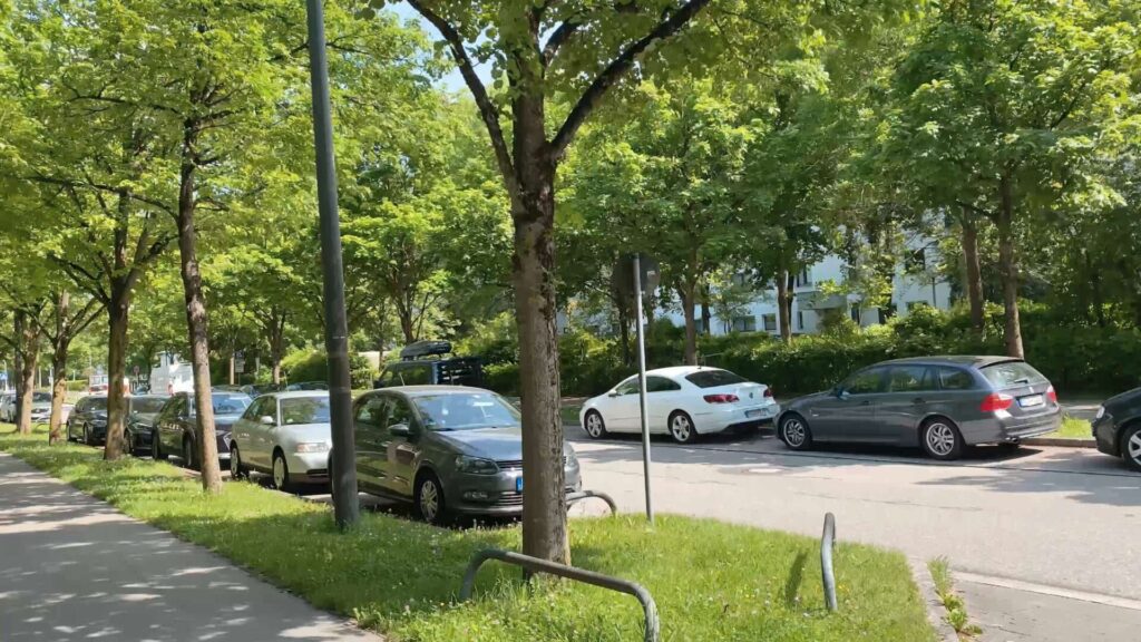 Baumgesäumte Wohnstraße mit parkenden Autos in der Umgebung einer Eigentumswohnung in München-Hadern