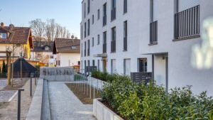 Paved path with planting beds leading to the new residential complex in Herrsching at sunset
