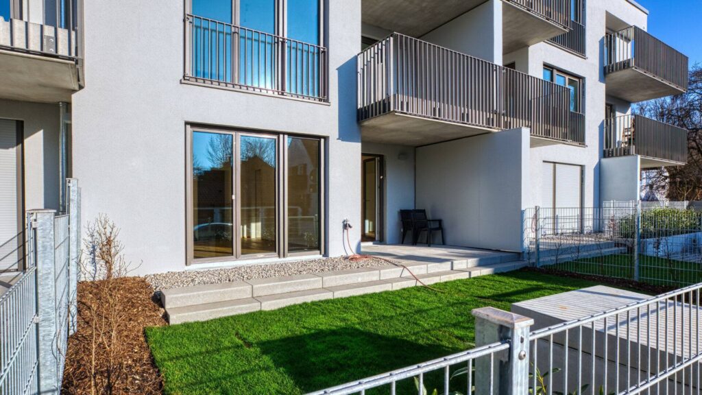 Patio with lawn area and access to the apartment via patio door in a new build apartment in Herrsching