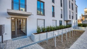 Modern front entrance with glass door and plant beds of a new building in Herrsching