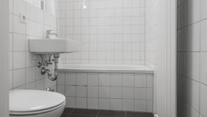 Older bathroom with sink, bathtub, and dark tiled floor in an apartment in Munich-Laim