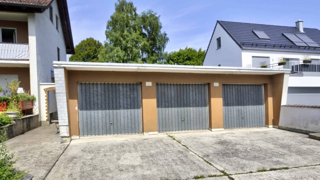 Garage mit drei Toren beim Haus in Lochhausen, umgeben von Nachbarhäusern