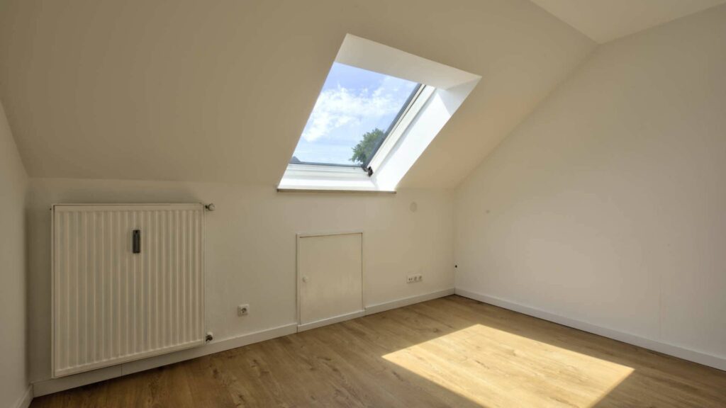 Leeres Zimmer des Hauses in Lochhausen mit Dachfenster, Dachschräge und Holzboden