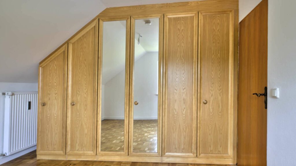 Großer Einbauschrank aus Holz im Dachzimmer des Hauses in Lochhausen mit Spiegeltüren