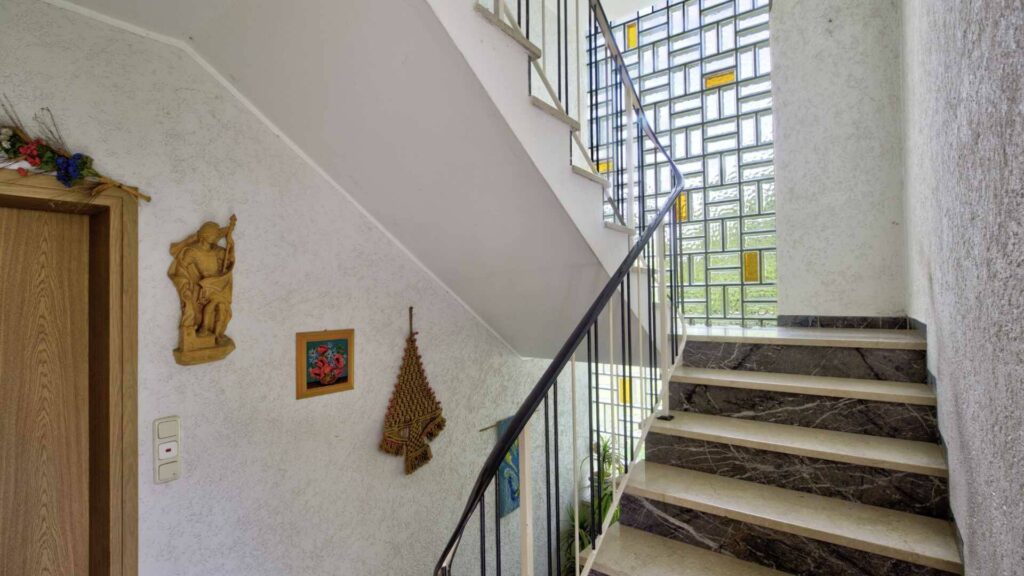 Treppenhaus des Hauses in Lochhausen mit gemauerten Stufen, Geländer und Wanddekoration