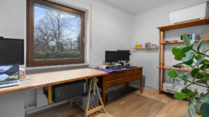 Helles Arbeitszimmer mit Schreibtisch, zwei Monitoren und Fensterausblick auf Bäume in Lochhausen