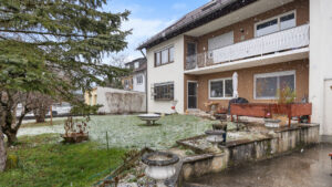 Rückansicht des Wohnhauses mit Balkon und leicht schneebedecktem Garten in Lochhausen