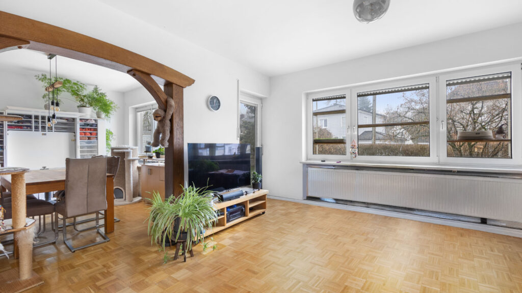 Offener Wohn-Essbereich mit Parkettboden, Holzbalken und großer Fensterfront in Lochhausen