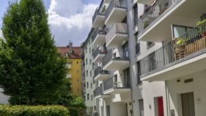 Modern residential building with wrap-around balconies and a tree in Ludwigsvorstadt, Munich