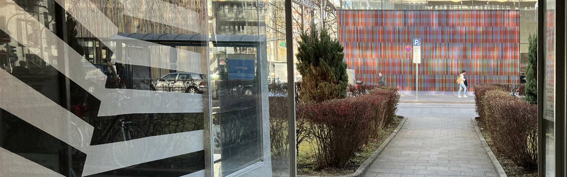 Panoramic storefront with a striped floor and a view of the courtyard of the retail space in Munich's Maxvorstadt district