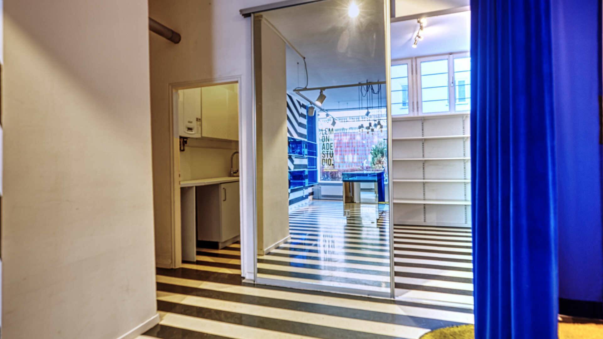 Corridor with striped floor and view into the sales area of the shop in Munich-Maxvorstadt