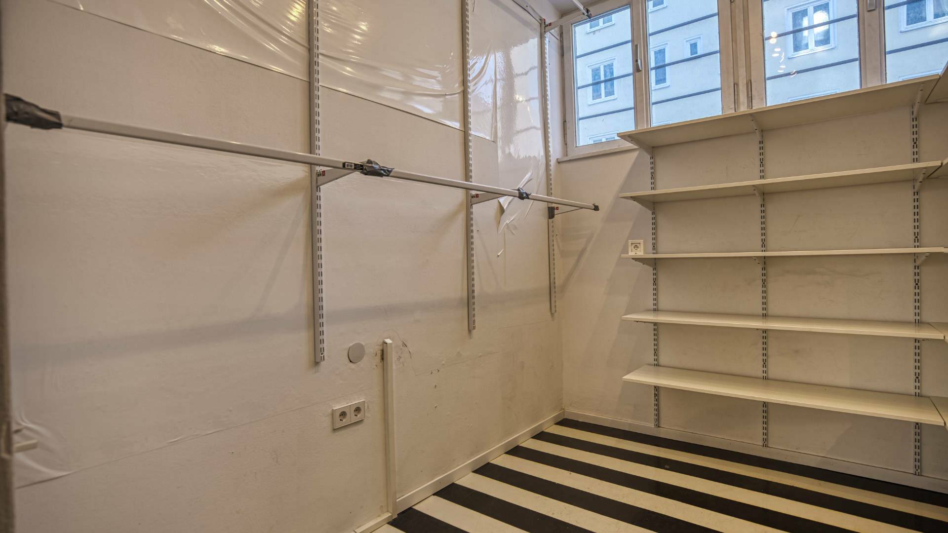 Empty storage room with wall shelves and a large window in the store in Munich's Maxvorstadt district