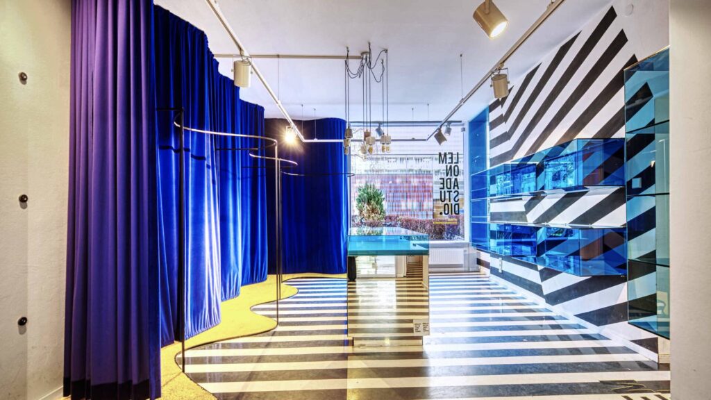 Salesroom with striped floor, blue curtains and mirrored wall in the shop in Munich-Maxvorstadt