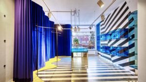 Salesroom with striped floor, blue curtains and mirrored wall in the shop in Munich-Maxvorstadt