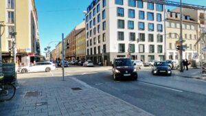Street intersection with old building facades and a modern office building near the retail space in Munich Maxvorstadt