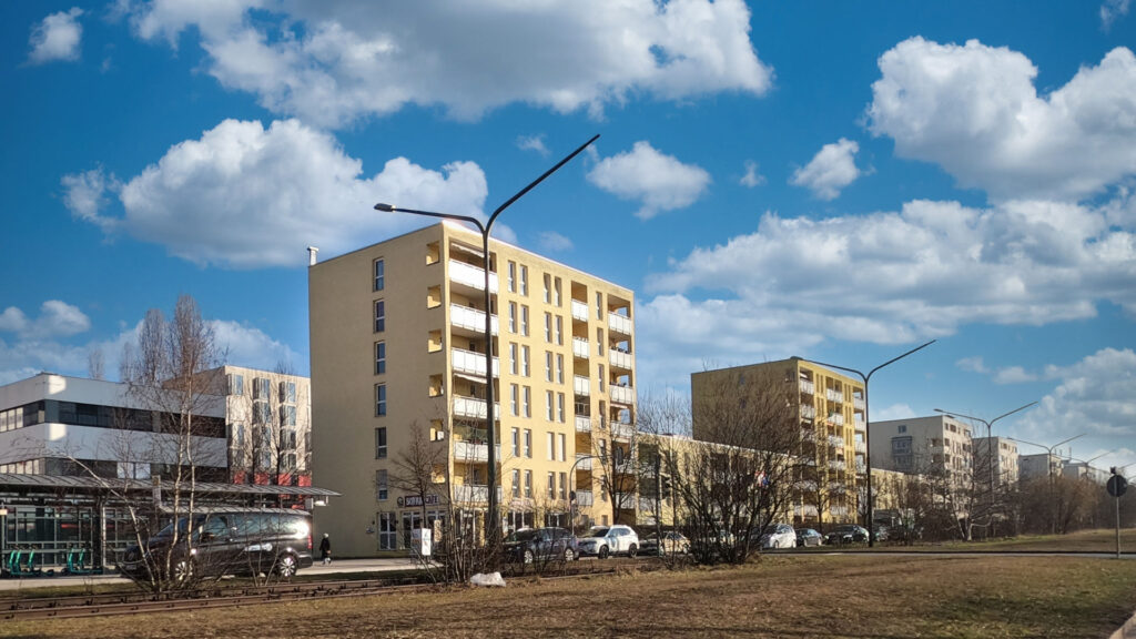 Yellow high-rise building with balconies next to other residential buildings in the Milbertshofen district of Munich