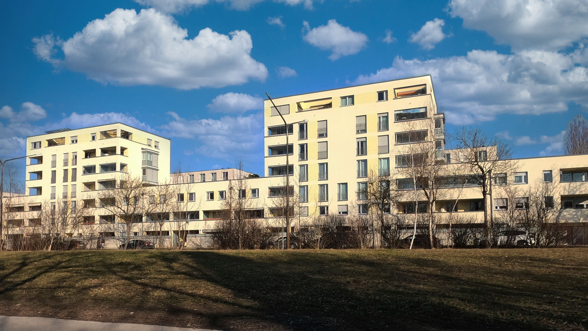 Moderne Wohnanlage mit mehreren Baukörpern und Rasenfläche im Stadtteil Milbertshofen in München