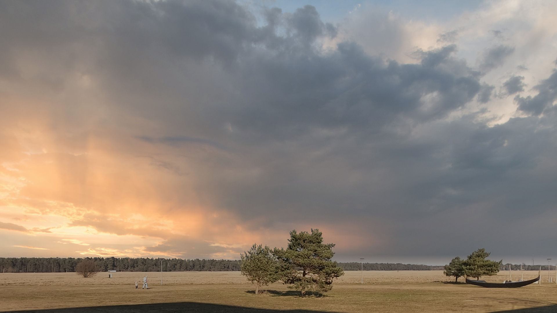 Dramatische Wolkenstimmung mit Sonnenuntergang über einer Heidefläche im Stadtteil Milbertshofen in München