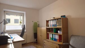 Living room of the apartment in Munich-Obersendling with desk, file cabinet and seating area