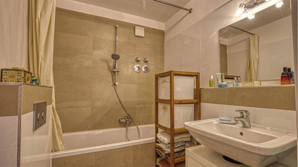 Bathroom of the apartment in Munich-Obersendling with bathtub, shower curtain and washbasin