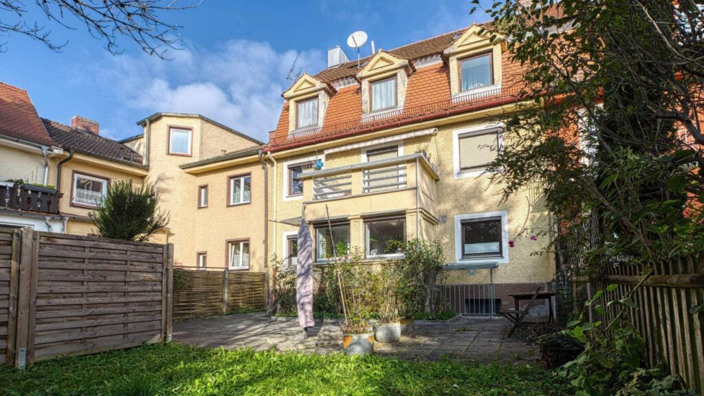 Rear view of the residential building in Munich-Obersendling with garden and paved terrace