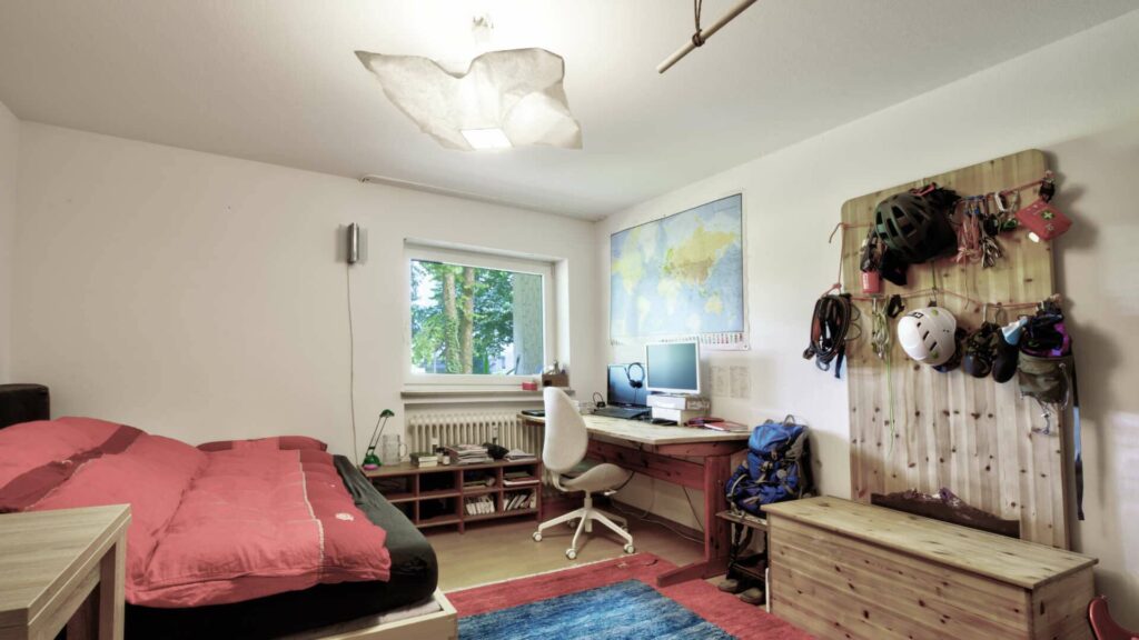 Bedroom with bed, desk and decorative wall design in a residential building in Munich-Perlach