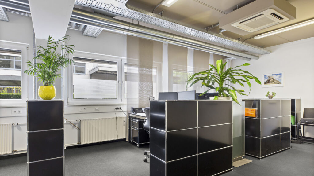 Office space with black filing cabinets and green plants in Puchheim – Rogers Immobilien