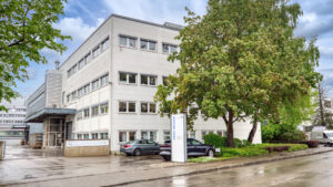 Building corner with tree and advertising pylon at the office building in Puchheim – Rogers Immobilien