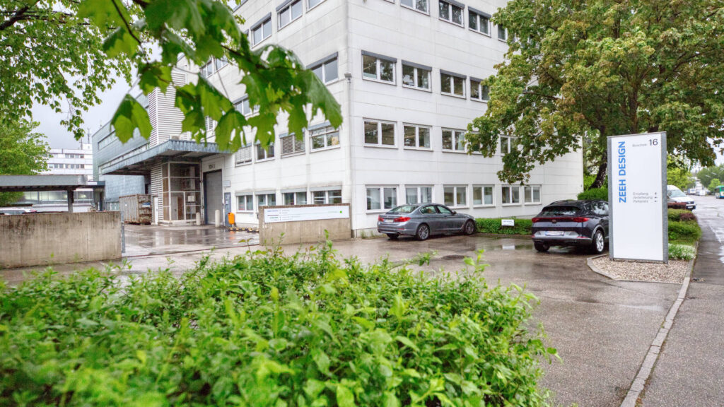 Entrance area of the office building with advertising pylon and parking spaces in Puchheim – Rogers Immobilien