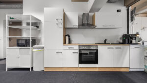Office kitchen with white fronts and built-in appliances in the Puchheim office building – Rogers Real Estate