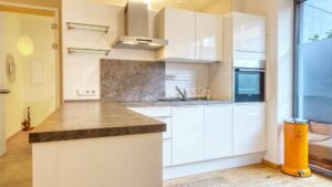 Kitchen installation with cooking island and extractor hood in the owner-occupied apartment in Munich-Schwabing – Rogers Immobilien